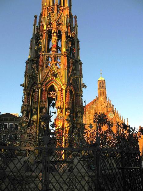 Norymberga 2010: Wieżyczka &quot;Schöner Brunnen&quot; z fontanną na Rynku Głównym. Tu już przy zachodzącym słońcu. Ma ona 19 metrów wysokości i obejmuje m.in. 40 kamiennych figur postaci z historii Świętego Cesarstwa Rzymskiego, ustawionych w czterech rzędach wokół wieży.